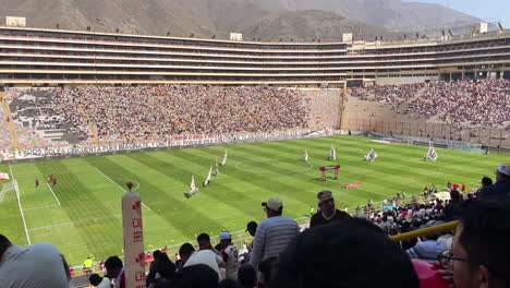 High-angle-shot-over-seats-filling-up-with-crowd-of-soccer-fans-during-a-match-in-Universitario,-Monumental,-Ate,-Lima,-Peru-at-daytime