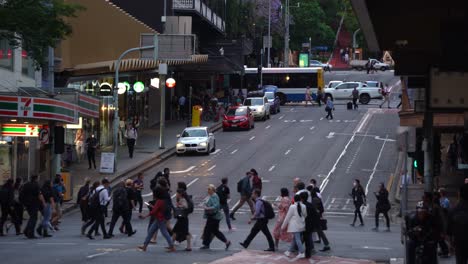 Cars-driving-down-Edward-Street-from-spring-hill-neighborhood,-busy-pedestrians-crossing-on-Adelaide-and-Ann-street-in-bustling-downtown-Brisbane-city-during-off-work-rush-hours