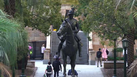 Straight-close-up-shot-of-the-scout-sculpture-at-war-memorial-Anzac-square-with-people-walking-towards-central-railway-station-through-underground-subway-at-off-work-rush-hours,-Brisbane-city