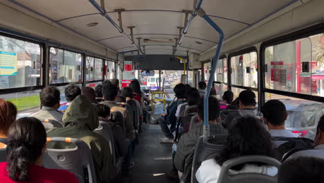 Shot-of-local-people-sitting-inside-a-public-bus-in-Lima,-Peru-on-a-sunny-day