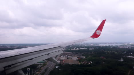 View-the-atmosphere-window-wing-of-a-Thai-Lion-Air-airplane-flight-in-sky-for-travel-transportation-on-holiday-at-Thailand