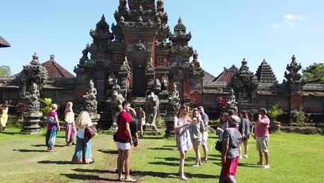 Tourists-Enjoying-a-Balinese-Temple-Wearing-Hippie-Fashion-Clothes-near-Ubud-Sky,-Indonesia