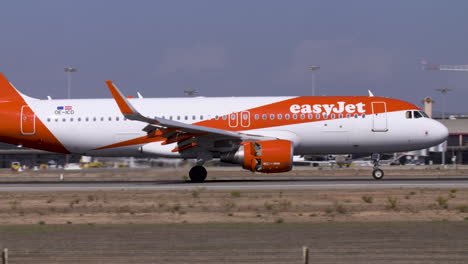 the-arrival-after-landing-of-an-easyjet-airbus-a320-plane-with-tourists-starting-their-vacation-at-faro-airport-in-portugal