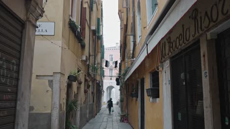 Slow-motion-of-an-old-woman-in-the-city-of-Venice-walking-away-in-an-empty-street