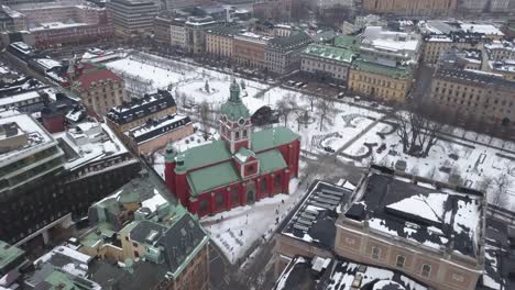 Aerial-footage-zooming-in-on-vibrant-Red-and-green-church-in-central-Stockholm,Sweden
