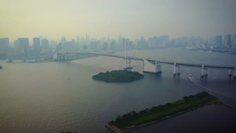 Aerial-view-of-rainbow-bridge-at-day-time-over-water-pan-left
