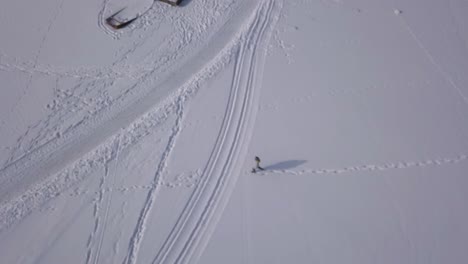 Glatte-Spiralförmige-Luftaufnahmen-Von-Jungen-Blonden-Mädchen,-Die-Durch-Schnee-Gehen
