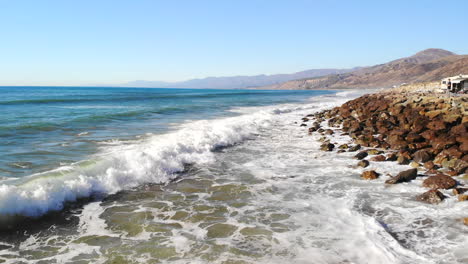 Eine-Epische-Luftdrohne,-Die-Von-Einer-Blauen-Meereswelle-Zu-Einem-Blick-Auf-Die-Goldenen-Strände-Und-Palmen-Der-Kalifornischen-Küste-Schoss