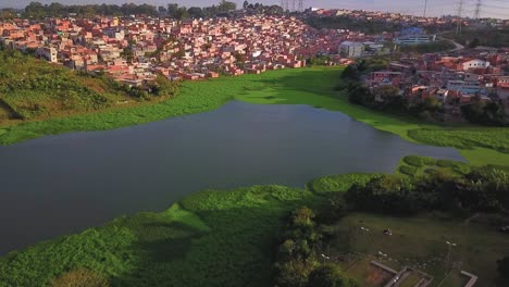 Hermosa-Vista-Aérea-Descendiendo-Sobre-Las-Favelas-De-Sao-Paulo-Y-La-Reserva-De-Agua