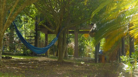 Blue-hammock-under-tree-with-spiral-stairs-on-background-and-change-of-light