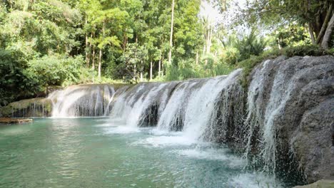 Tripod-shot-of-water-flowing-from-Cambugahay-Falls-into-natural-turquoise-pool-in-Siquijor-Island,-the-Philippines-in-ultra-slow-motion