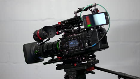 Close-up-shot-of-a-Sony-PMW-F5-4K-digital-cinema-camera-with-a-Fujinon-XK6-lens-mounted-to-a-Sachtler-Video-20p-tripod-head-on-a-Kessler-Shuttle-Dolly-slider
