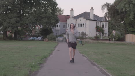 Young-Athletic-Man-Goes-For-A-Run-In-The-Park,-Runs-Towards-Camera-In-Slow-Motion---Ungraded
