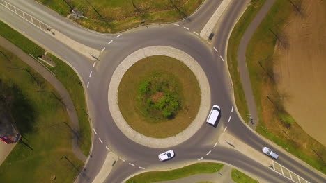 Topshot-aerial-drone-footage-of-a-roundabout-with-four-roads-direction-traffic
