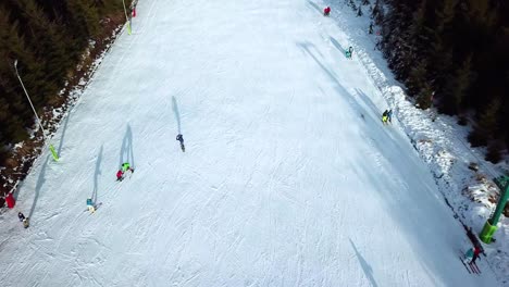 Luftaufnahme-Eines-Snowboarders,-Der-Herunterfällt,-Aufsteht-Und-Weiter-Den-Hang-Hinunter-Auf-Dem-Schneegipfel-Von-Topolita,-Siebenbürgen---Rumänien,-Abfährt