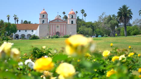 Looking-up-at-the-Santa-Barbara-Mission-on-a-sunny-summer-day-with-yellow-roses-in-the-foreground