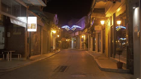Motor-bike-drives-down-village-street-with-Christmas-lights-night-time