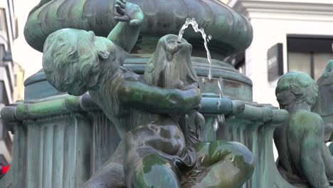 Close-up-of-boy-and-fish-water-fountain-in-Vienna-city-center