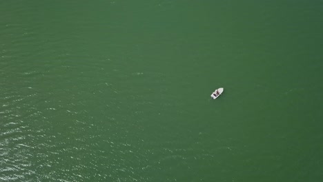 Aerial-circle-Panning-shot-of-boat-in-the-middle-of-lake---reservoir-just-floating