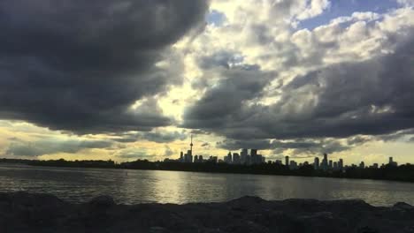 Wide-shot-of-lake-and-dynamic-sky-set-against-Toronto-city-skyline-in-the-distance