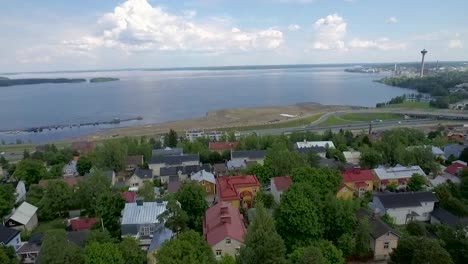 Drone-shot-of-historical-Pispala-area-dividing-two-lakes,-Pyhäjärvi-and-Näsijärvi,-in-Tampere-and-a-look-over-the-city-center