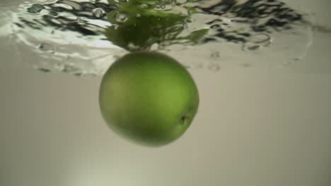 An-apple-is-dropping-into-the-water-and-staying-at-the-water-surface