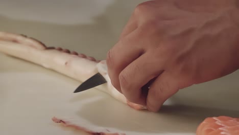 Ein-Koch-Schneidet-In-Einer-Restaurantküche-Vorsichtig-Mit-Einem-Messer-Einen-Oktopustentakel