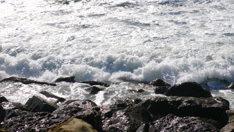 Eine-Meereswelle,-Die-In-Zeitlupe-Aus-Nächster-Nähe-Gegen-Die-Felsen-Eines-Kalifornischen-Strandes-An-Der-Küste-Bricht
