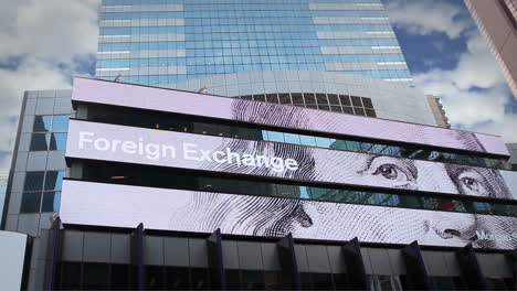 Tripod-mounted-shot-of-the-digital-financial-ticker-on-the-Morgan-Stanley-headquarters-in-New-York-City,-showing-various-foreign-currency-exchange-rates