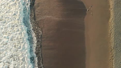 Aerial-top-down-flying-forward-over-waves-breaking-at-sandy-beach