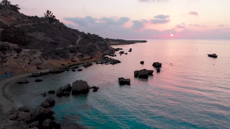 Aerial-rising-shot-from-the-beach-to-the-sky-over-Konnos-Bay-at-sunset