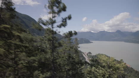 Elevated-View-of-spring-Howe-sound-from-Gondola,-fast-moving-trees-in-foreground