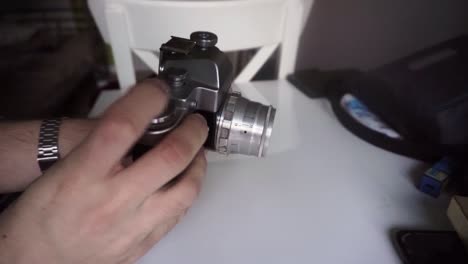 Hands-winding-film-roll-in-retro-chrome-camera