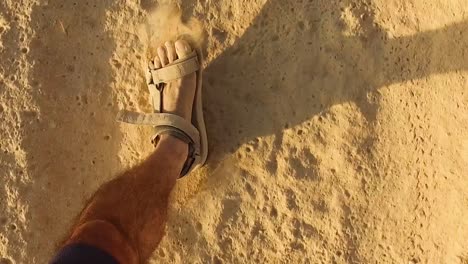 Man-Walking-in-Sandals-Along-a-Sandy,-Dusty-Track---Point-of-View