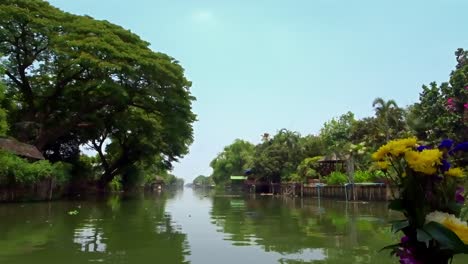 View-looking-out-from-the-front-of-a-boat-moving-slowly-along-on-a-canal-in-Thailand