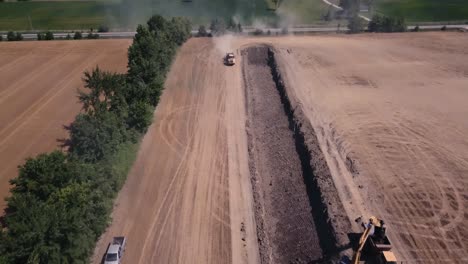 Drone-shot-fly-over-multiple-heavy-machinery-digging-a-trench