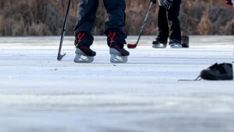 A-low-to-the-ground-shot-of-people's-skates-only-as-they-play-pond-hockey
