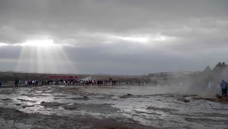 Estático,-Plano-General,-De-Mucha-Gente-Mirando-El-Geisir-En-Erupción,-En-Un-Día-Nublado-De-Otoño,-En-Geysir,-Islandia