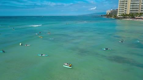 Drone-footage-of-surfers-off-the-coast-of-Waikiki-beach,-on-the-island-of-Oahu,-Hawaii