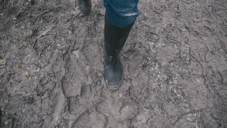Muddy-boots-walking-along-a-muddy-path-in-slow-motion