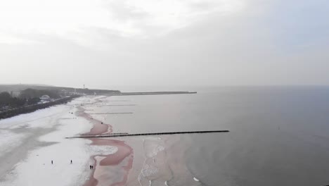 Aerial-shot-of-sandy-beach-in-Ustka-in-winter