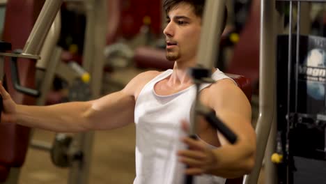 Extreme-Nahaufnahme-Eines-Jugendlichen-Bodybuilders,-Der-Vertikale-Brustpresseübungen-Auf-Einer-Maschine-In-Einem-Fitnessstudio-Macht