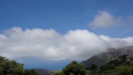 TIME-LAPSE:-Clouds-passing-by-over-mountains-on-a-sunny-island