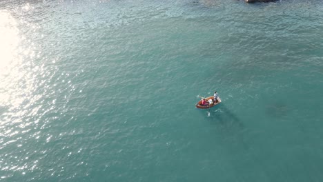 Approaching-from-the-top-by-drone-a-small-fishing-rowing-boat-in-the-ocean