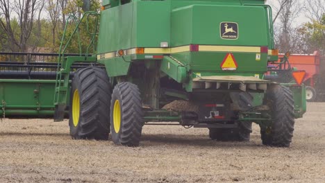 John-Deere-9600-Combines-driving-on-an-empty-field-that-used-to-be-a-soybean-farm,-after-finished-harvesting