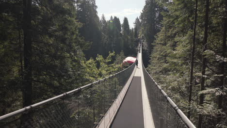 Woman-walking-on-empty-suspension-bridge-with-Canadian-flag