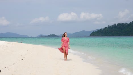 Tiro-En-Cámara-Ultra-Lenta-De-Una-Joven-Sonriente-Caminando-En-Una-Hermosa-Playa-En-Una-Isla-En-Tailandia