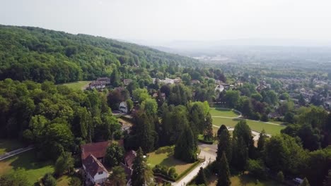 Drone-shot-over-trees-and-building-in-Riehen,-Switzerland