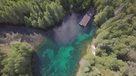 Aerial-drone-shot-over-crystal-blue-water-of-Kitch-iti-kipi,-the-big-spring,-in-Palms-Book-State-Park,-Michigan