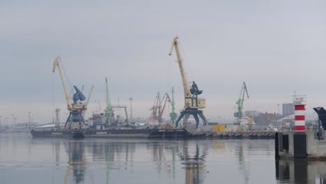 industrial-port-seen-from-distance-with-tall-cranes-and-icy-cold-water-with-moody-cloudy-sky